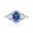 Elegant ring with a blue gemstone and diamond accents on a white background