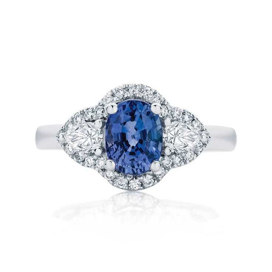 Elegant ring with a blue gemstone and diamond accents on a white background