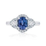 Elegant ring with a blue gemstone and diamond accents on a white background